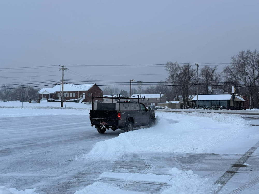 image of truck plowing snow in a parking lot