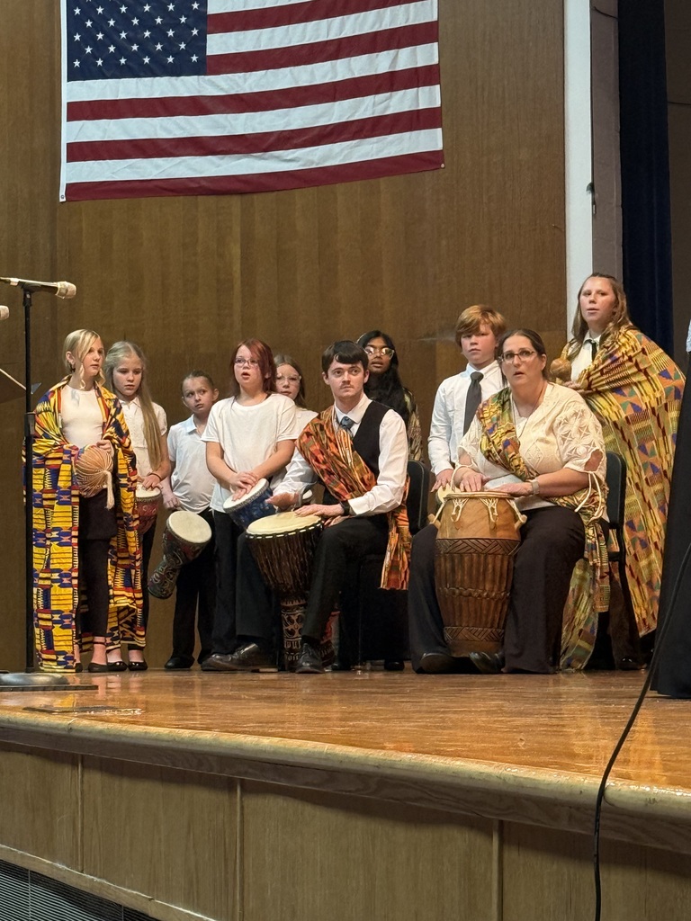 two teachers playing drums with students 