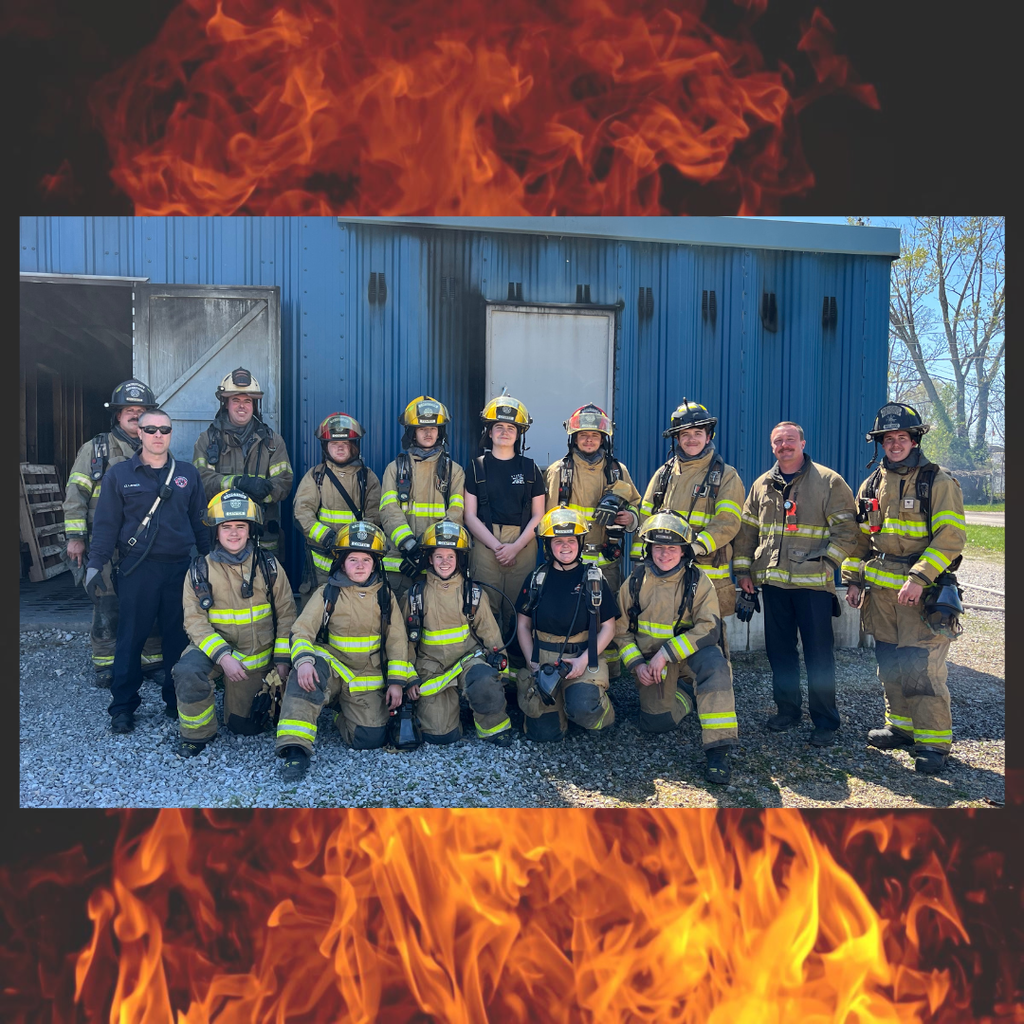 Image of a group of students and and adults in firefighting uniforms.