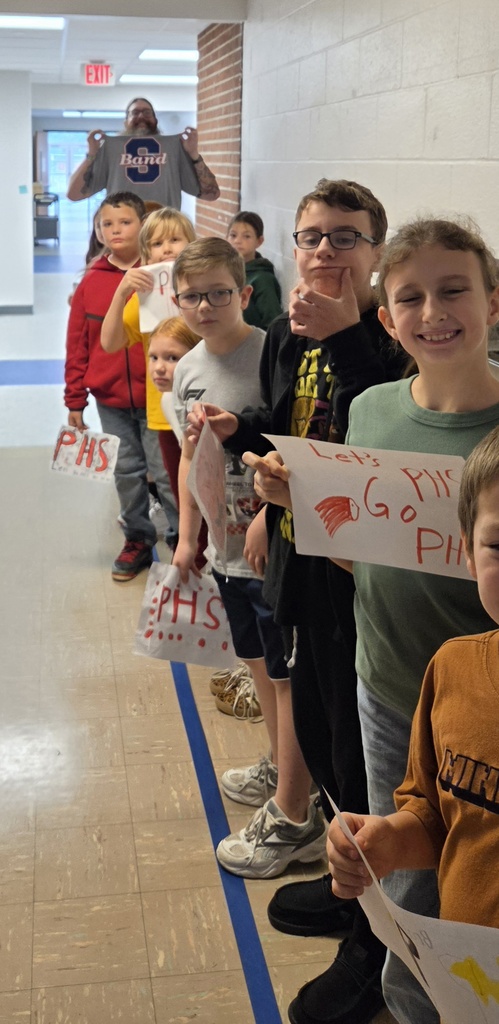 Group of 5 students holding signs and cheering for the high school band.