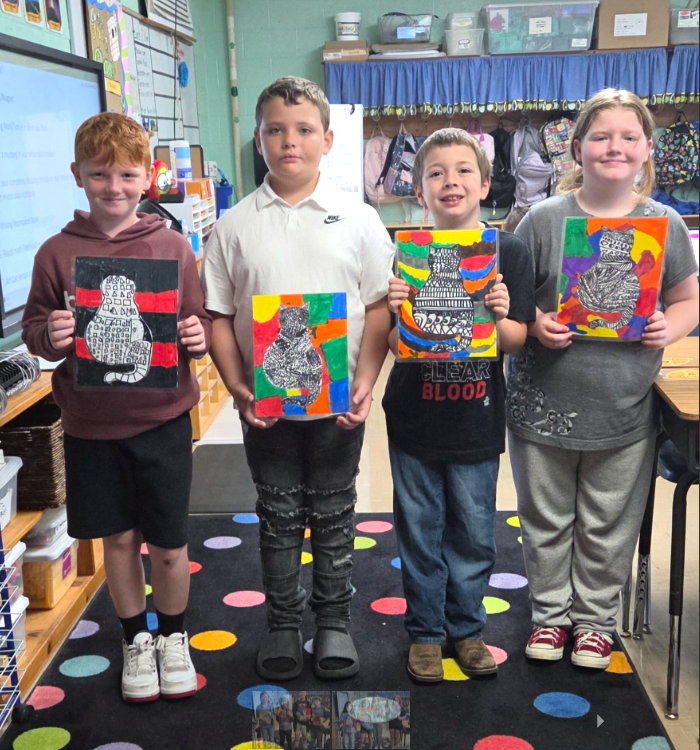 Four students, (L-R boy, boy, boy, girl) smiling and holding their zentangle cat artwork.