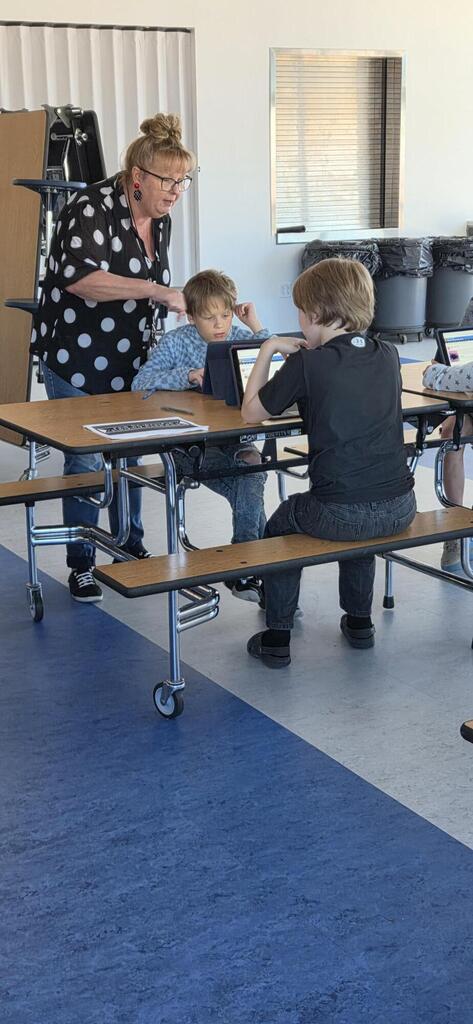 Teacher helping two students do science fair research.