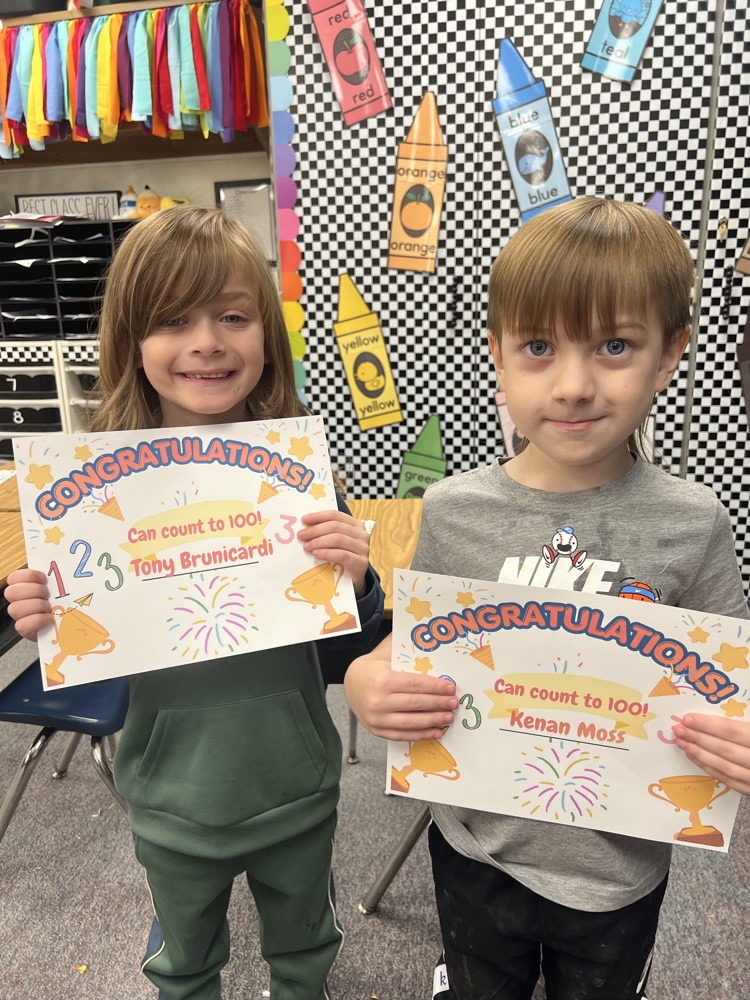two male students pose with their certificates for counting to 100