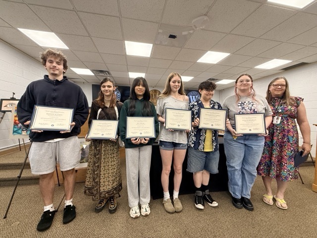 image of students standing in a line in a board room holding certificates