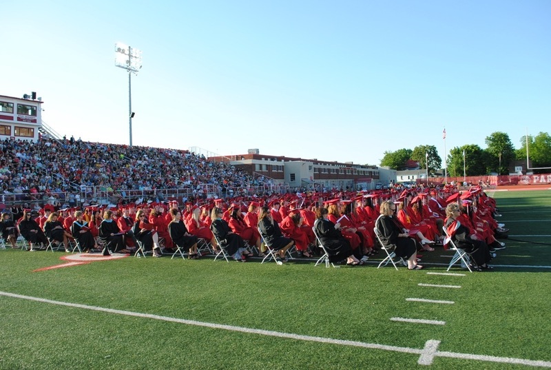 graduates sitting and listening to speaker
