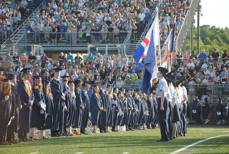 grads and crowd standing at attention