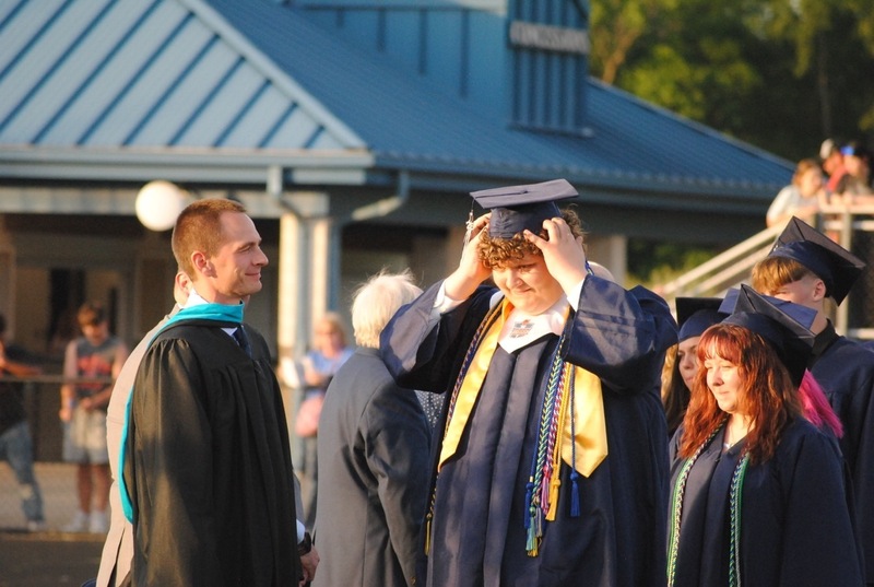 student preparing to receive diploma