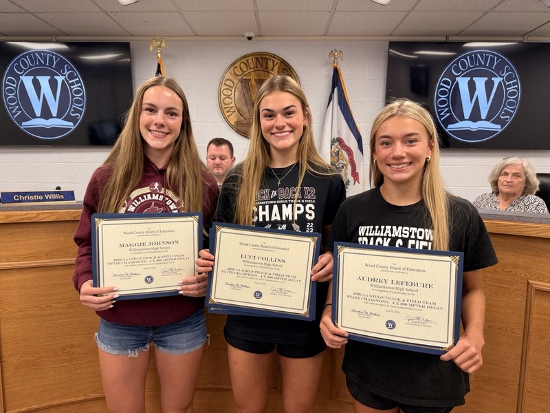 Team members smiling with certificate