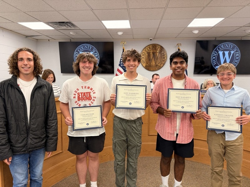 Team members smiling with certificate