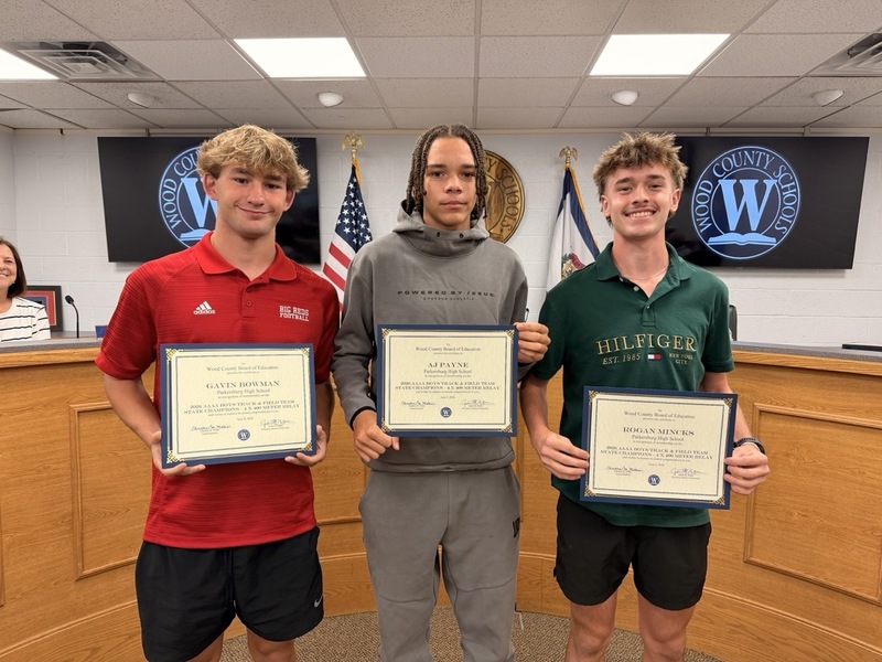 Team members smiling with certificate