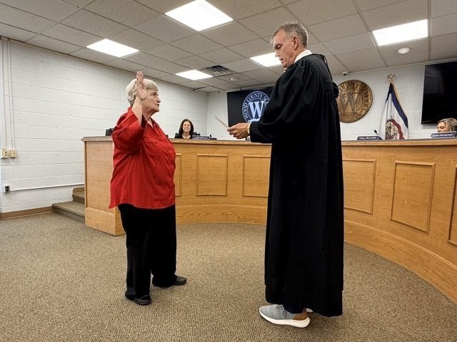 judge jason wharton stands swearing in board member debbie hendershot