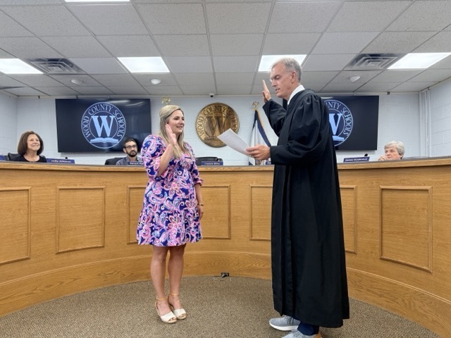 judge jason wharton stands swearing in board member haley meredith