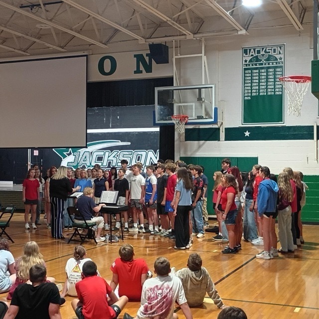 middle school choir performing in a gymnasium for student body