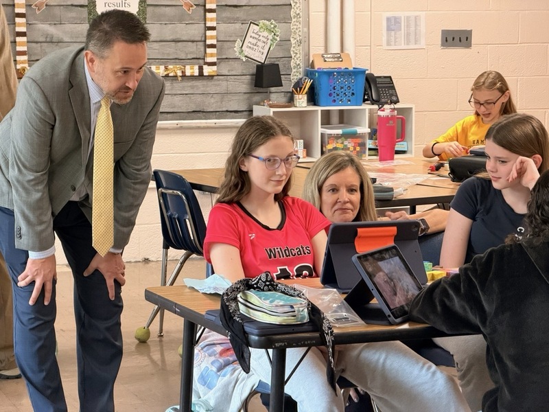 students explaining project to adults