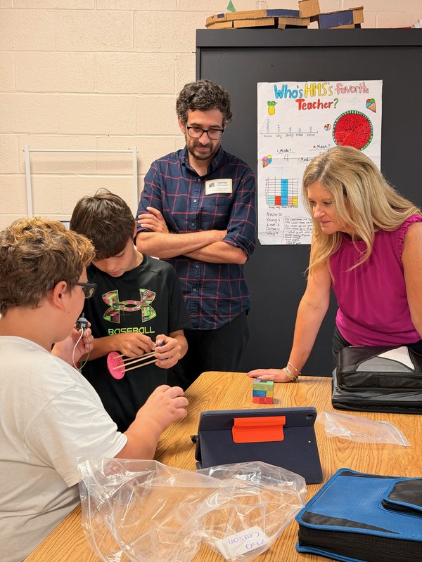 students explaining project to adults