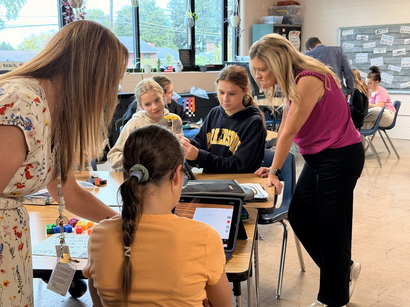 students explaining project to adults