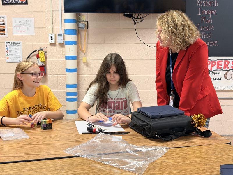 students explaining project to adults