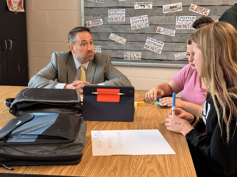 students explaining project to adults