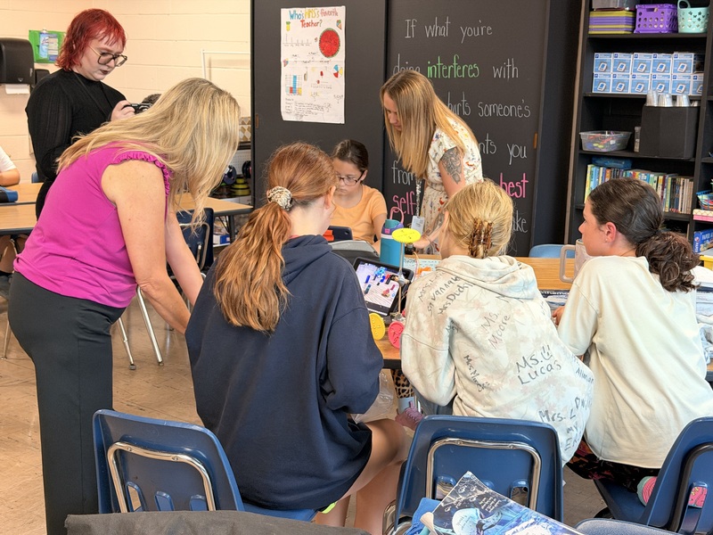 students explaining project to adults