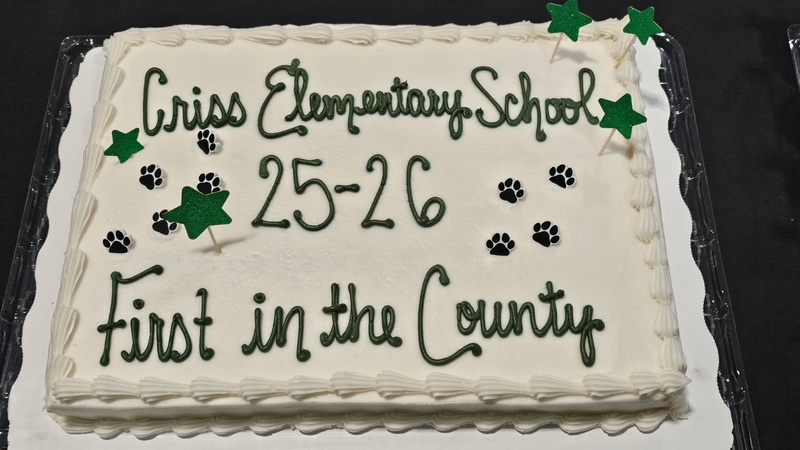 white frosted cake that says, in green frosting, "Criss Elementary School 25-26 First in the County