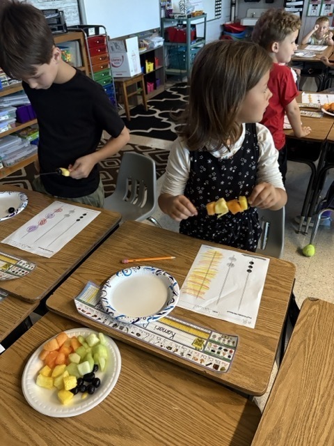 image of two students using food to make connections between shape and healthy eating