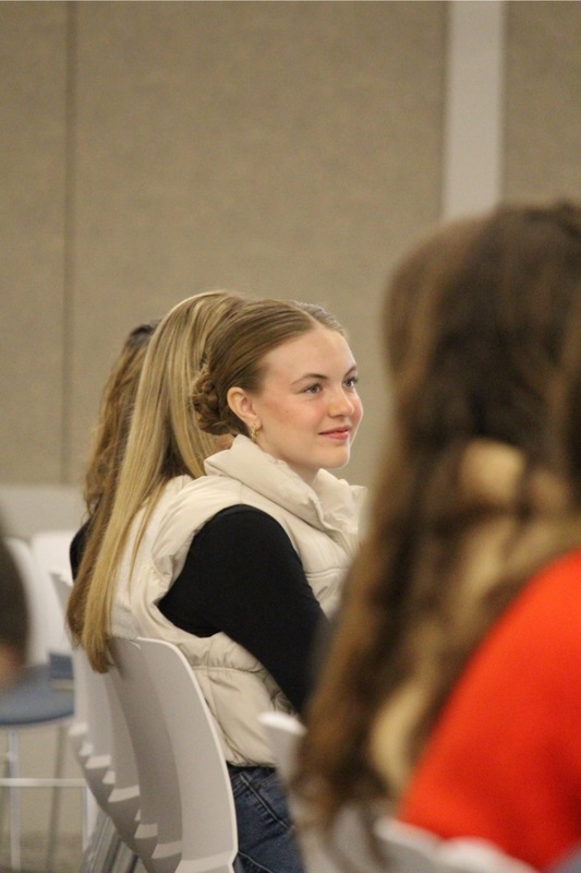 Student smiling, and watching presentation