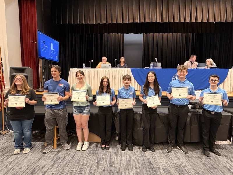 Group of students holding an award in front of the Board of Education