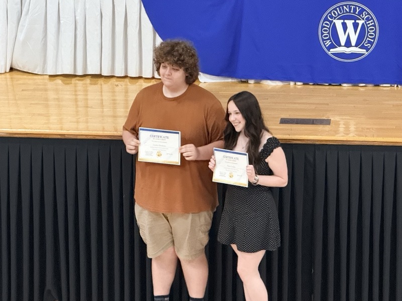 students standing in front of Parkersburg High School Auditorium and receiving certificates for music/choral awards