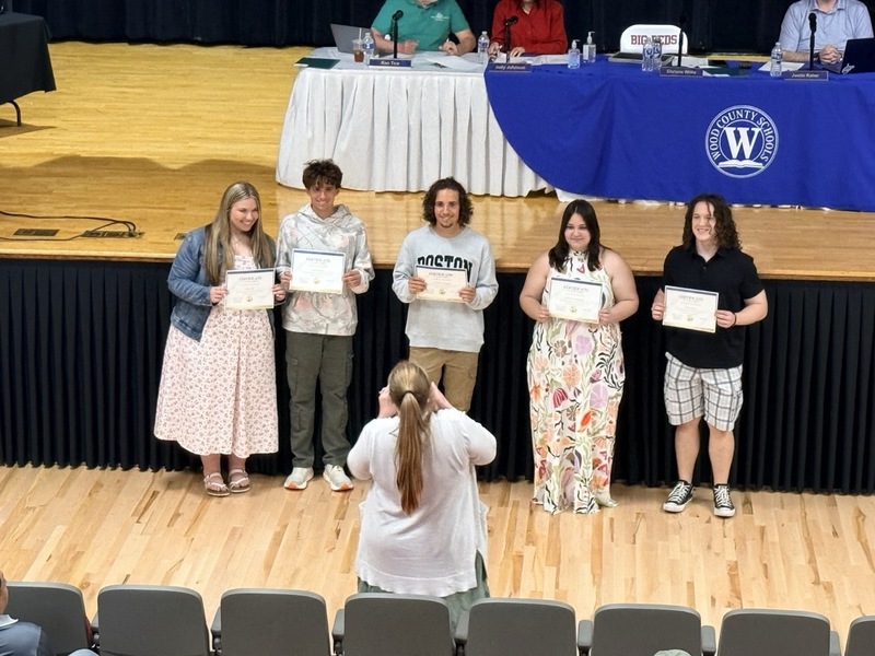 students standing in front of Parkersburg High School Auditorium and receiving certificates for music/choral awards