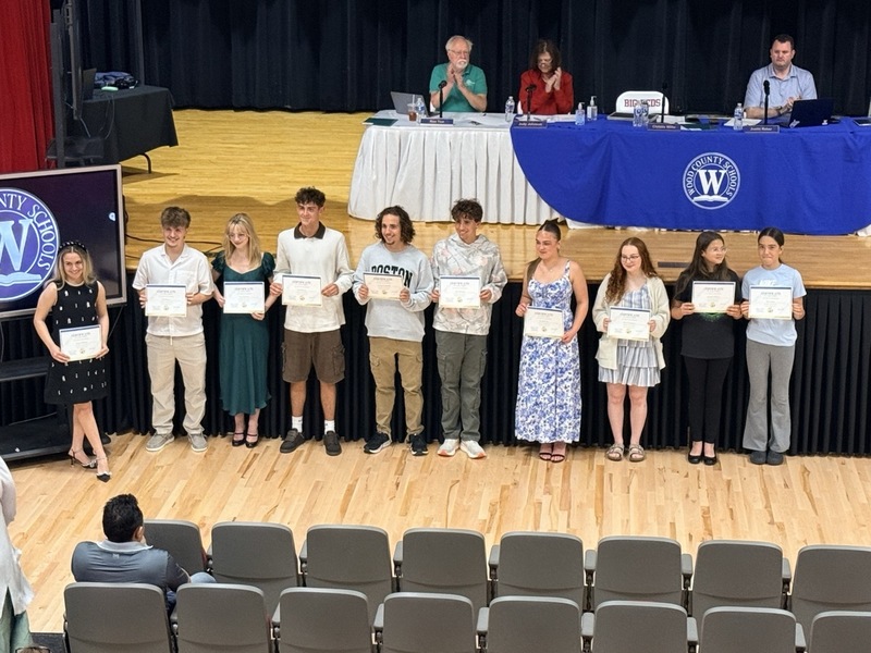 students standing in front of Parkersburg High School Auditorium and receiving certificates for music/choral awards
