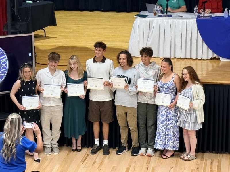 students standing in front of Parkersburg High School Auditorium and receiving certificates for music/choral awards