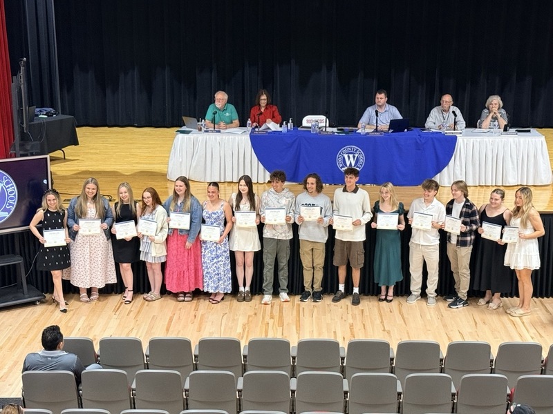 students standing in front of Parkersburg High School Auditorium and receiving certificates for music/choral awards