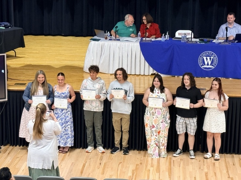 students standing in front of Parkersburg High School Auditorium and receiving certificates for music/choral awards