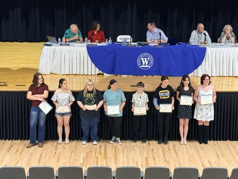 students standing in front of Parkersburg High School Auditorium and receiving certificates for music/choral awards