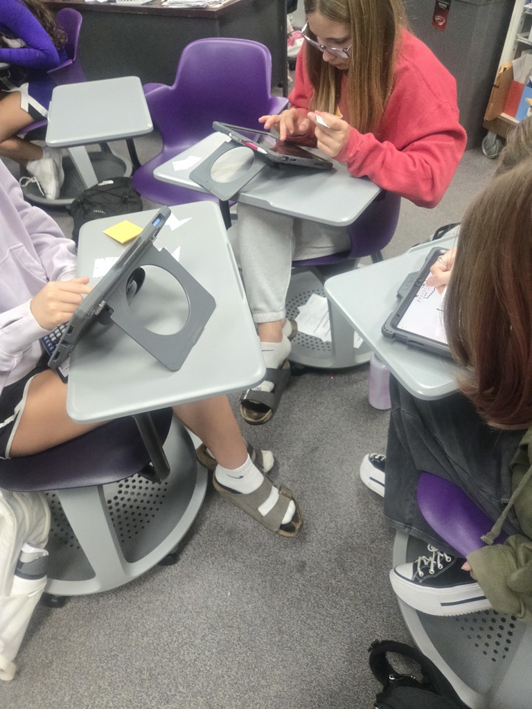 Algebra 1 students working together and showing work on ipads.