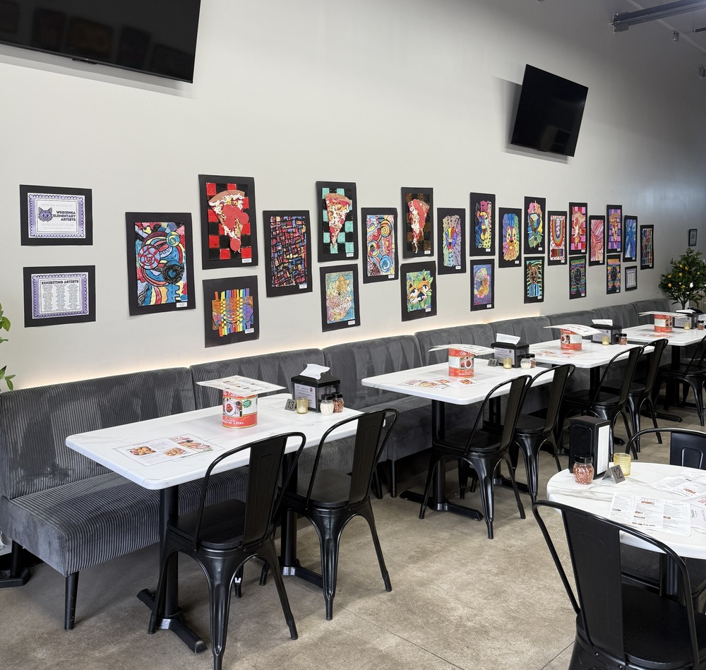 student art hanging on walls at restaurant