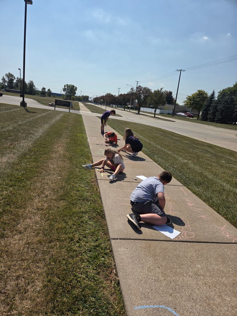 students drawing with sidewalk chalk