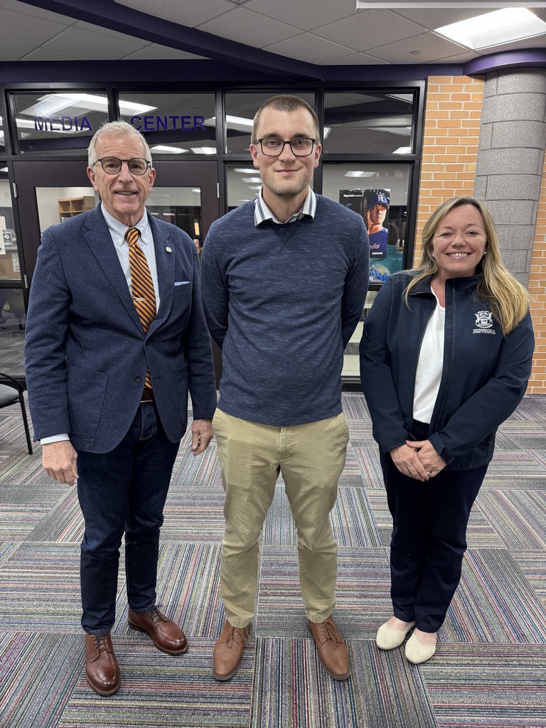 two men and a woman stand together