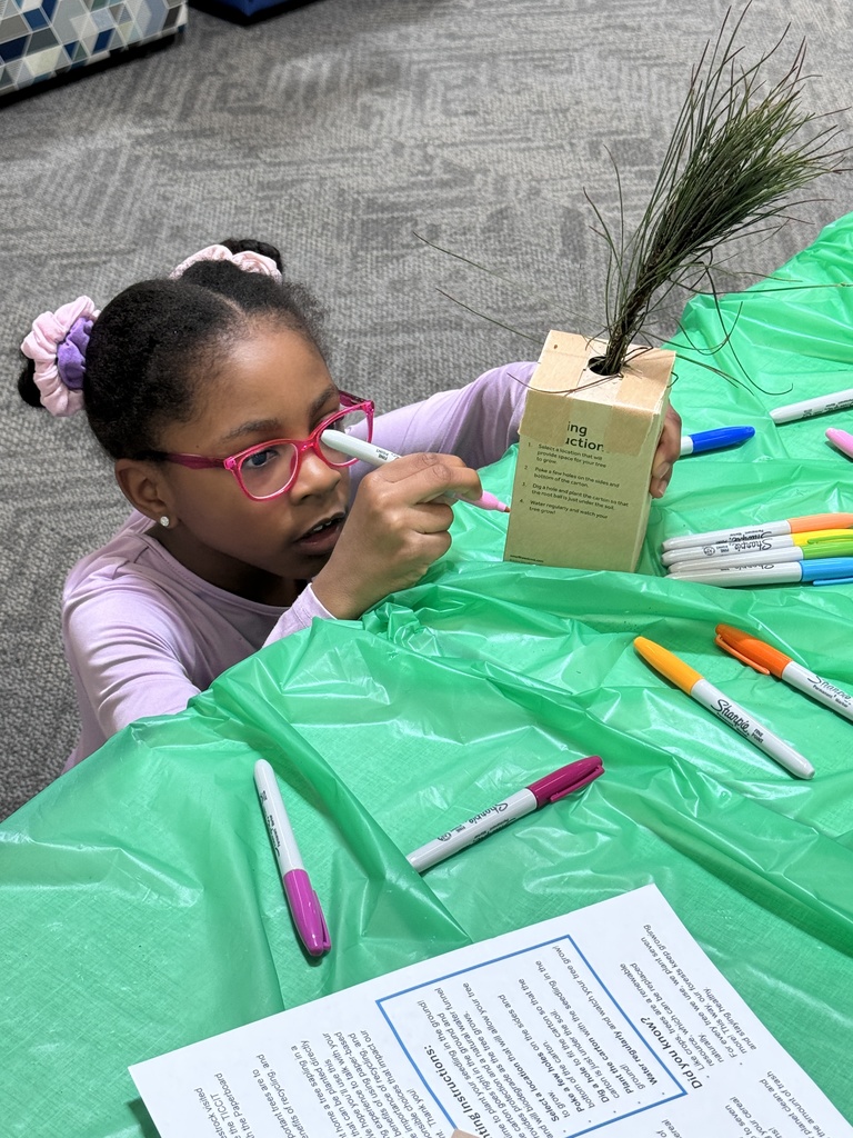 student writing their name on a box