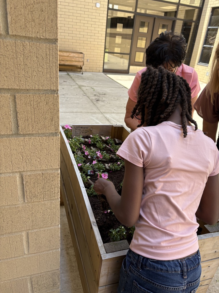 students weed and plant flowers at wue