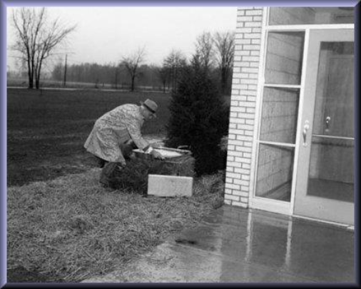 old black and white photo of man putting something in a box