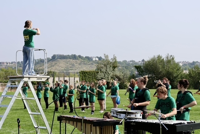 Marching band students on the field playing for the crowd