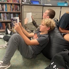 Students sitting in bean bag chairs reading books