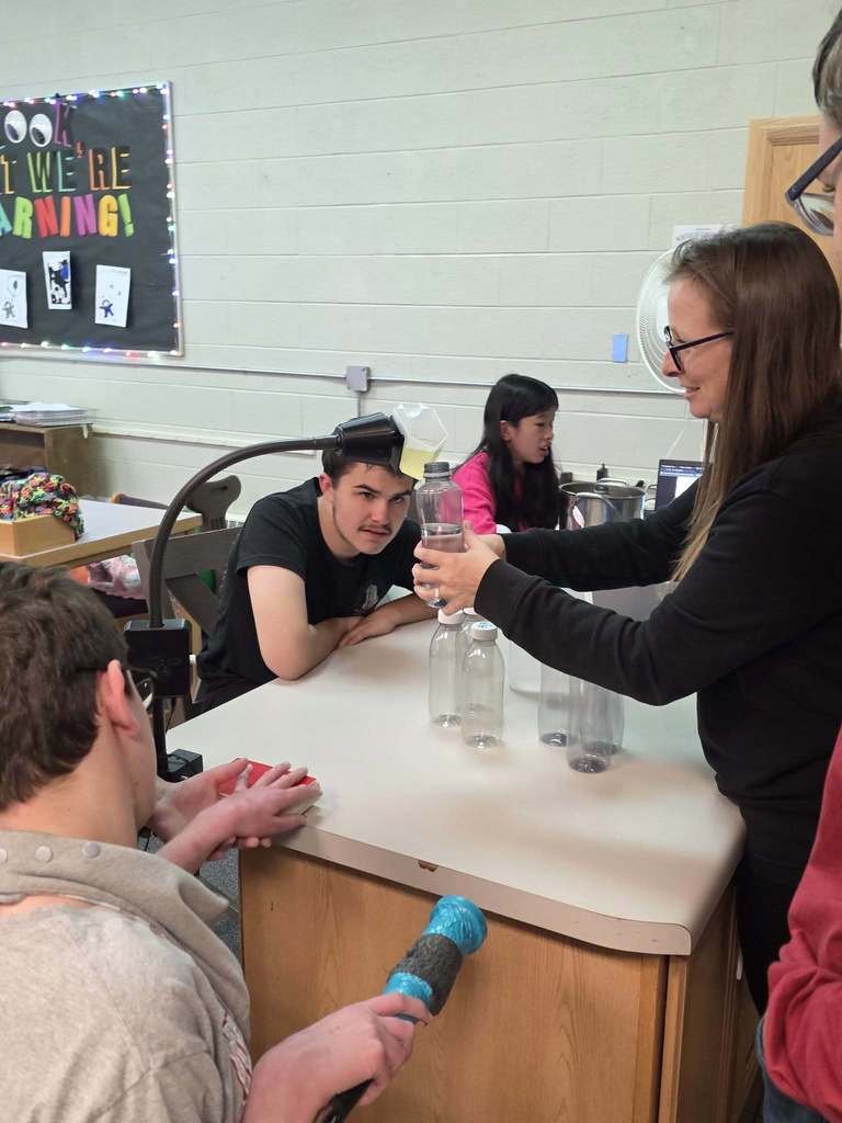 Mrs. Snook and a few of her students creating a "galaxy bottle"