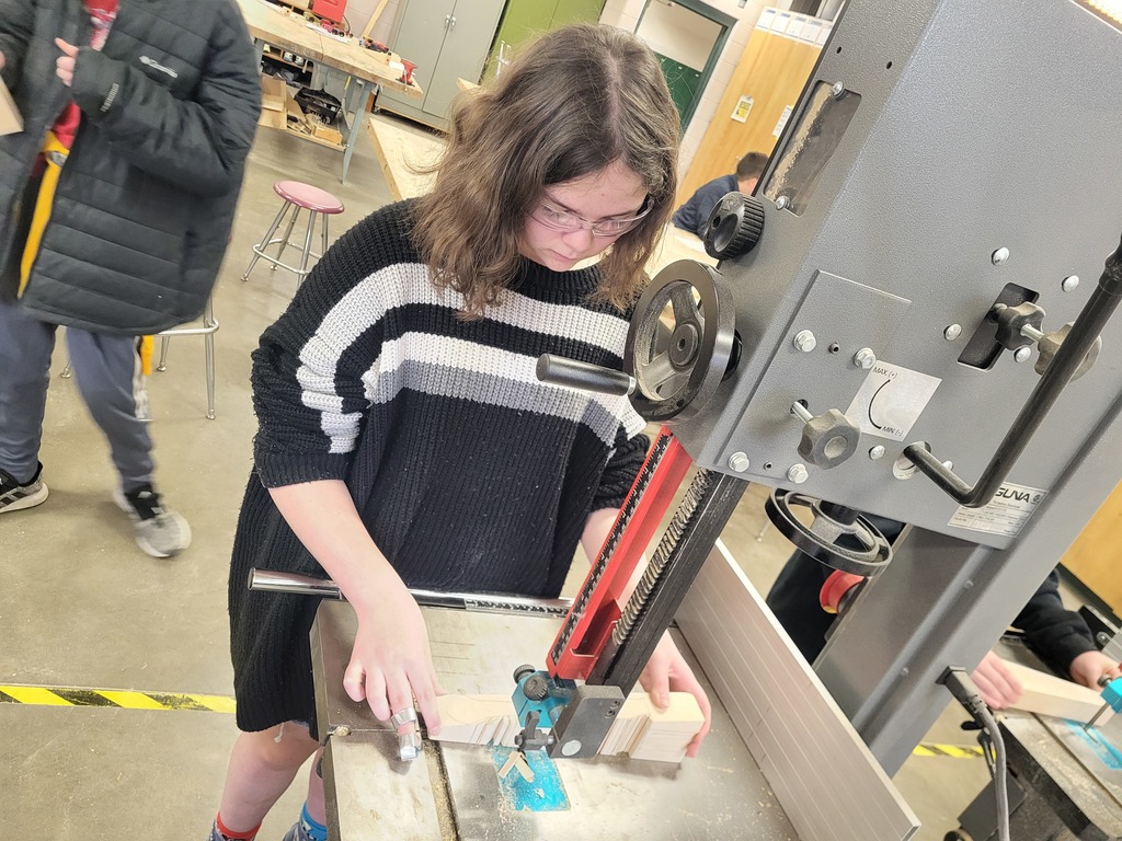 Student using Woodshop tools to build her CO2 car