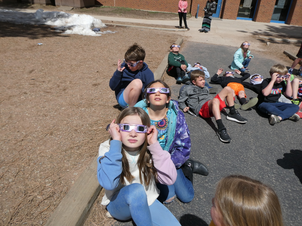 Students wearing protective eye wear and looking up at the solar eclipse