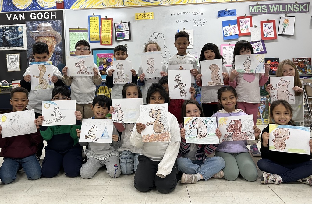 Class photo holding Groundhog Day artwork at Elementary