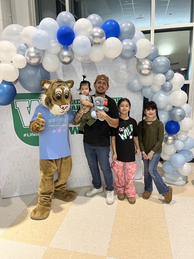 Family poses with mascot at WinterFest, Feb. 2026