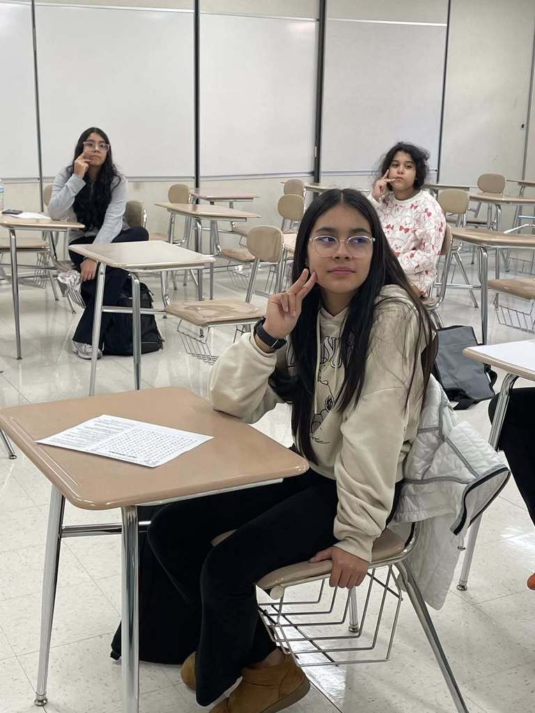 Students repeating the signs the teacher is showing them