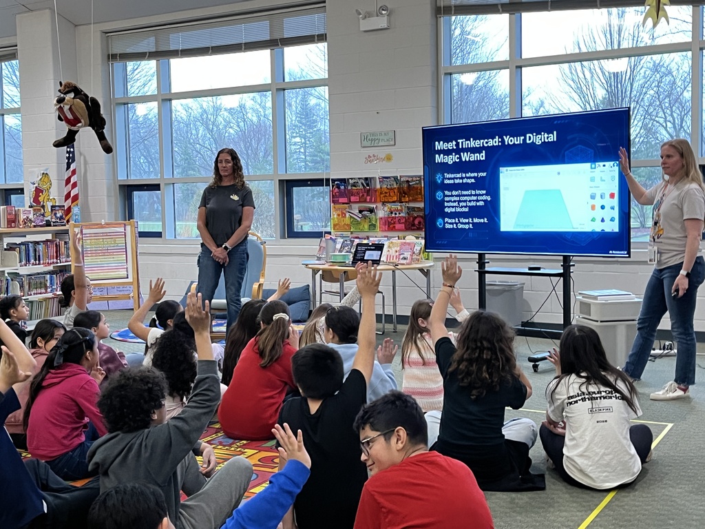 students raise hands to answer a question during a presentation in the school library